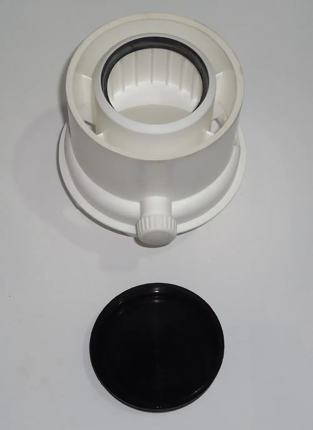 Weißer Kunststoffadapter mit Griff und schwarzem Deckel, geeignet für die Installation von Heiz- oder Klimaanlagen, möglicherweise von Daikin.